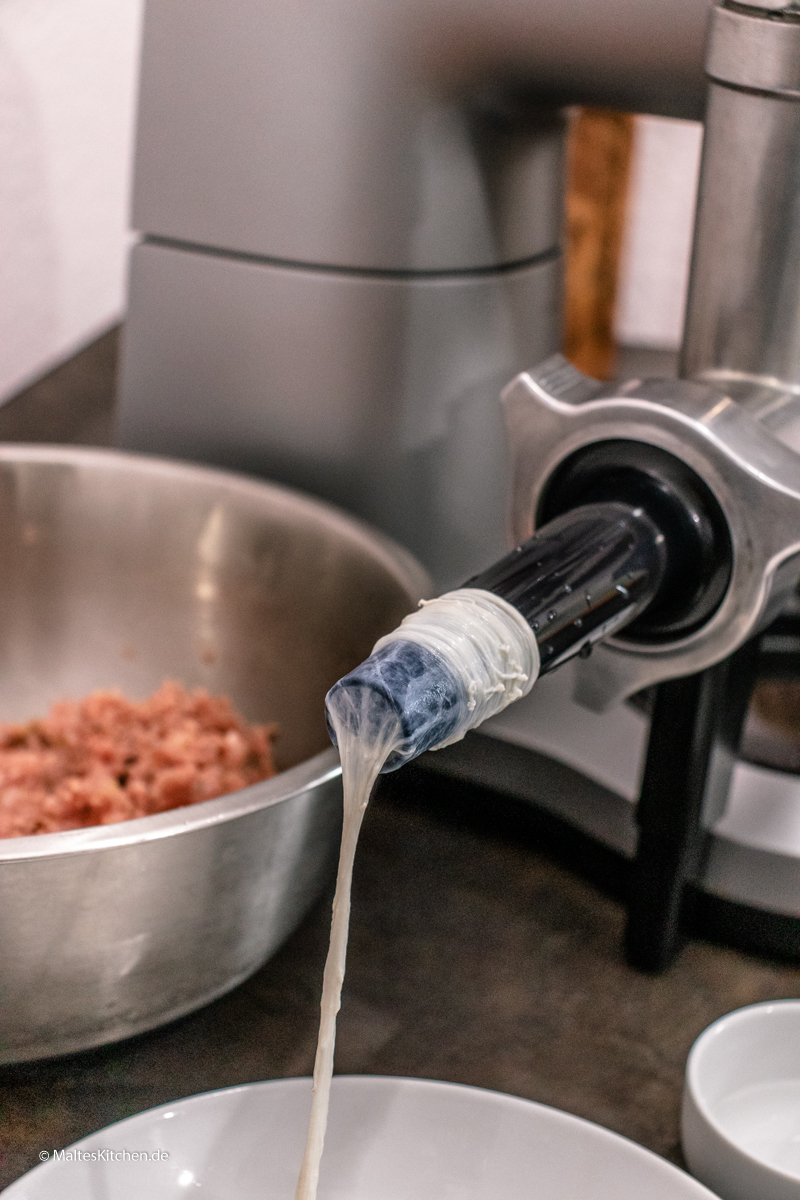 Der Darm wird auf den Wurstfüller gezogen.