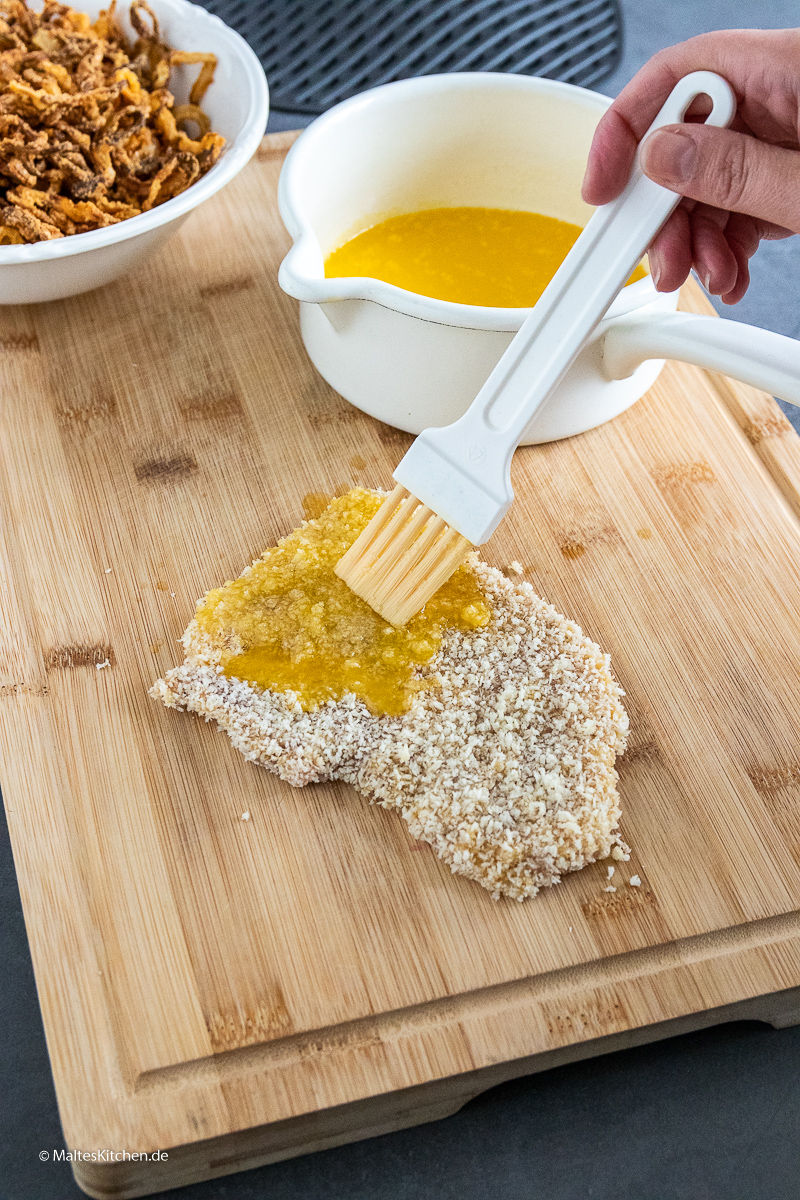 Das Schnitzel wird mit Butter eingepinselt.