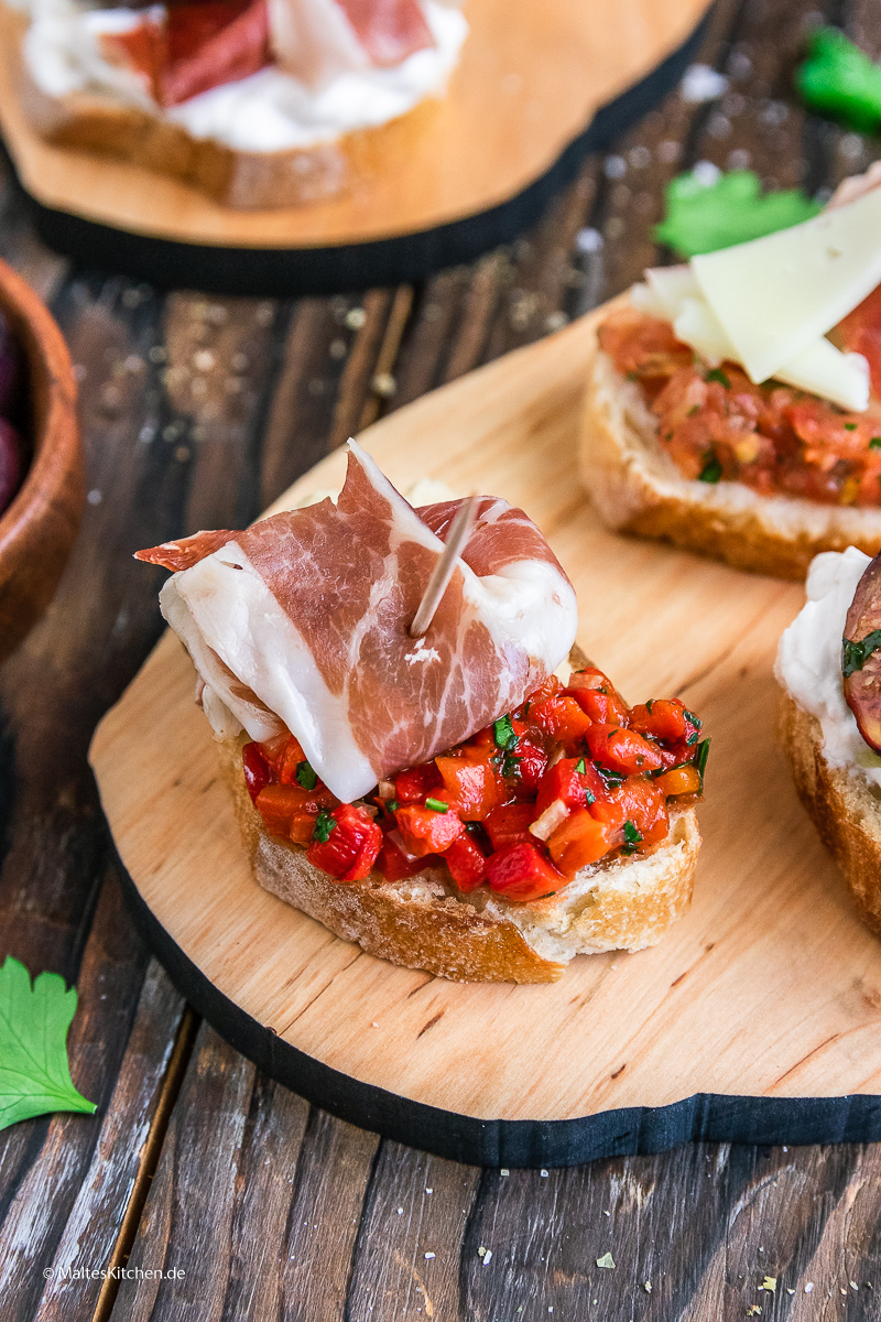 Pintxos mit Bohnenmus, paprika-Salsa und Serrano-Schinken.