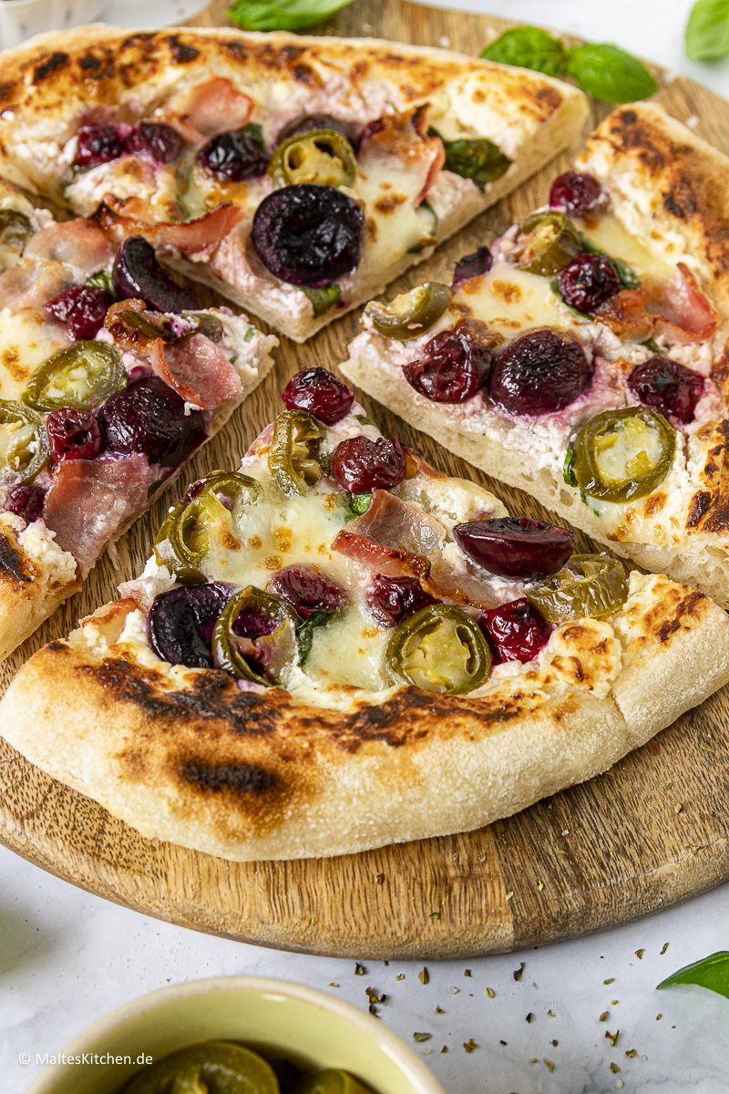 Eine knusprige Pizza mit Kirschen, Bacon und Spinat.