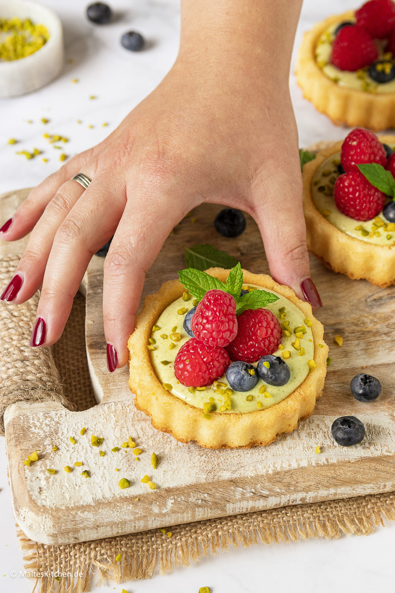 Leckerer Biskuitboden mit Pistazien-Creme und Himbeeren und Blaubeeren.