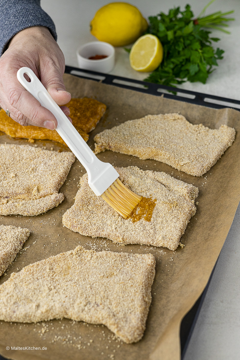Die Schnitzel werden paniert und mit Butterschmalz bestrichen.