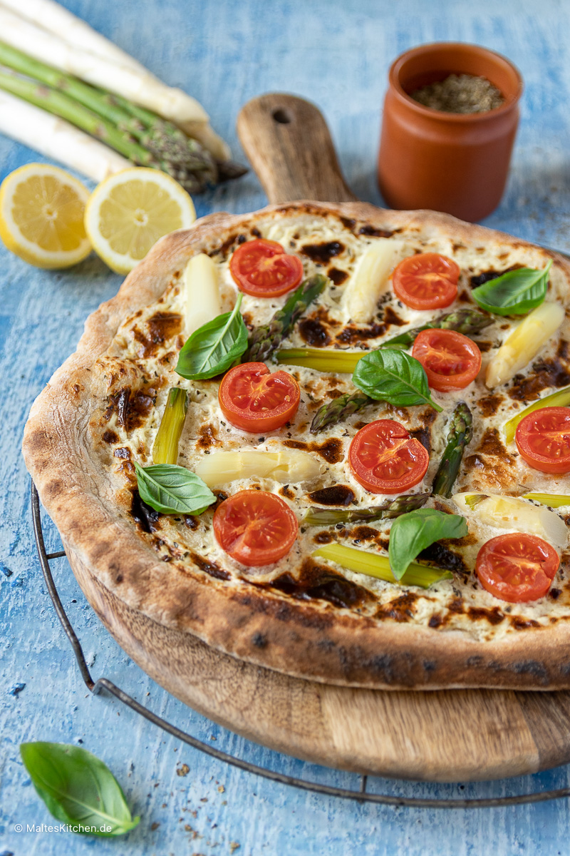 Leckere Spargelpizza mit weißem und grünem Spargel und fruchtigen Tomaten.