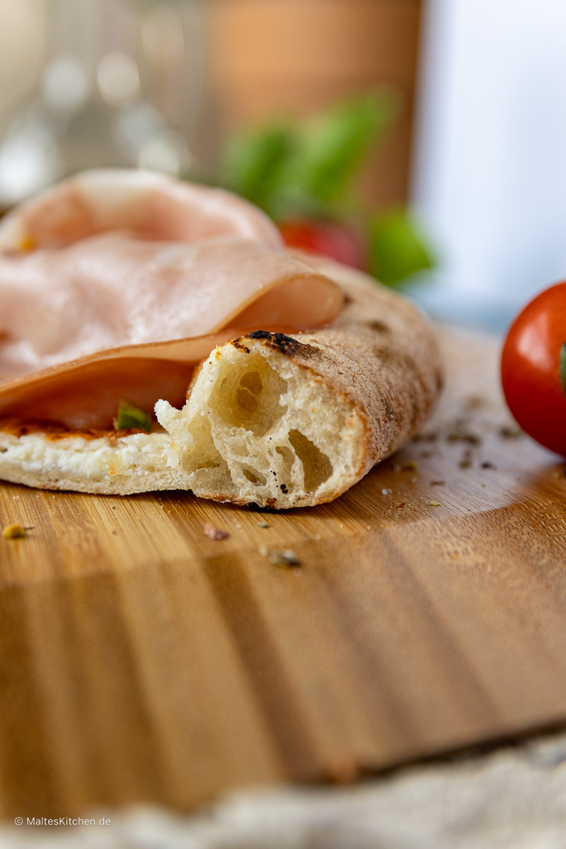 Der Rand der Pizza wird fluffig und knusprig.