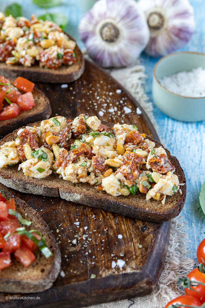Geröstetes Brot mit getrockneten Tomaten, Mozzarella und Pinienkernen.