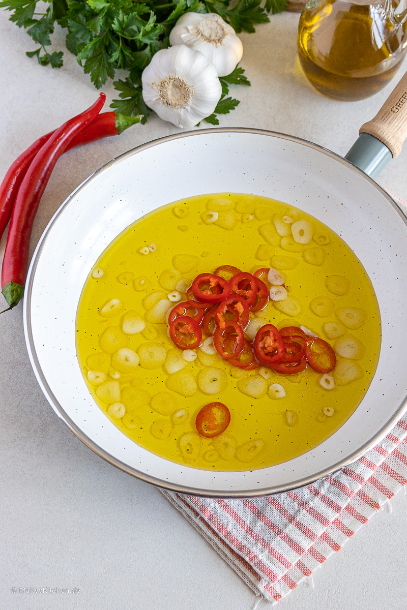 Der Knoblauch für die Spaghetti aglio e olio wird in reichlich Olivenöl gebraten.