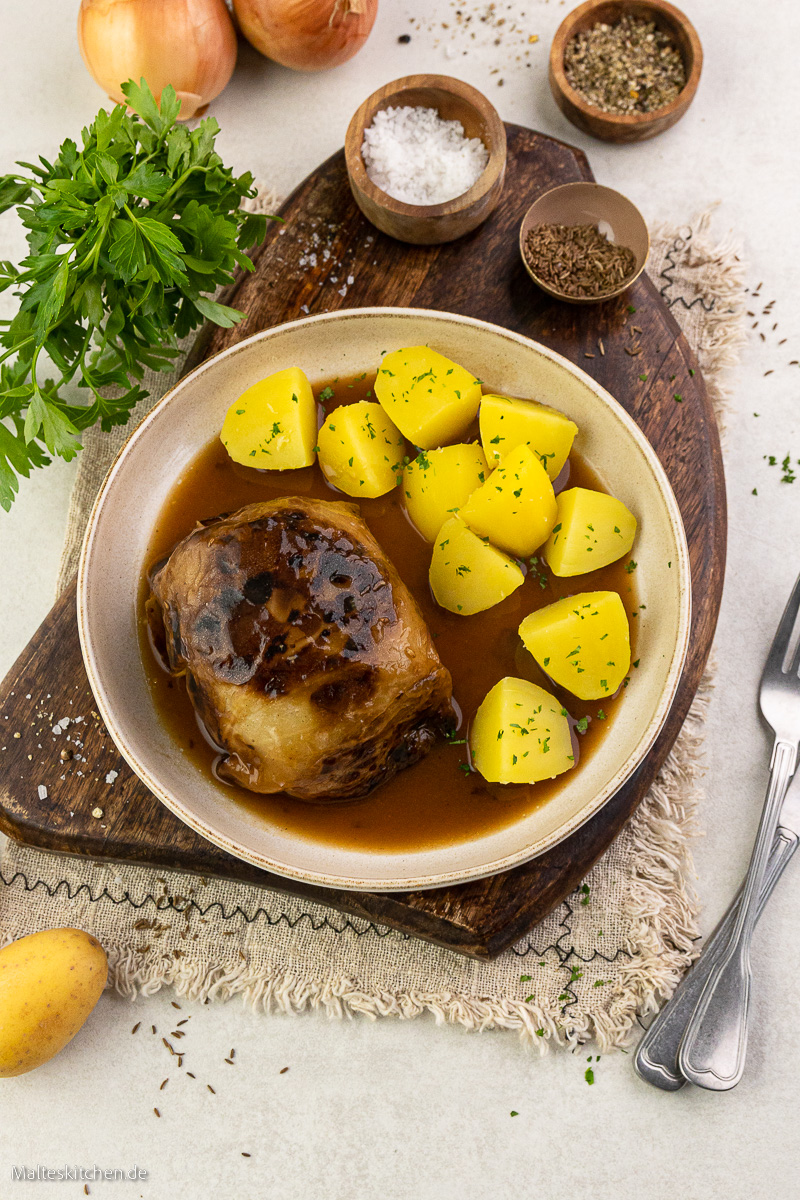 Kohlrouladen mit brauner Soße und Kartoffeln.