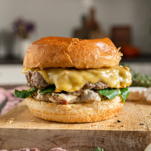 Burger mit Champignons in Pilzrahmsauce, geschmorten Zwiebeln und Bergkäse