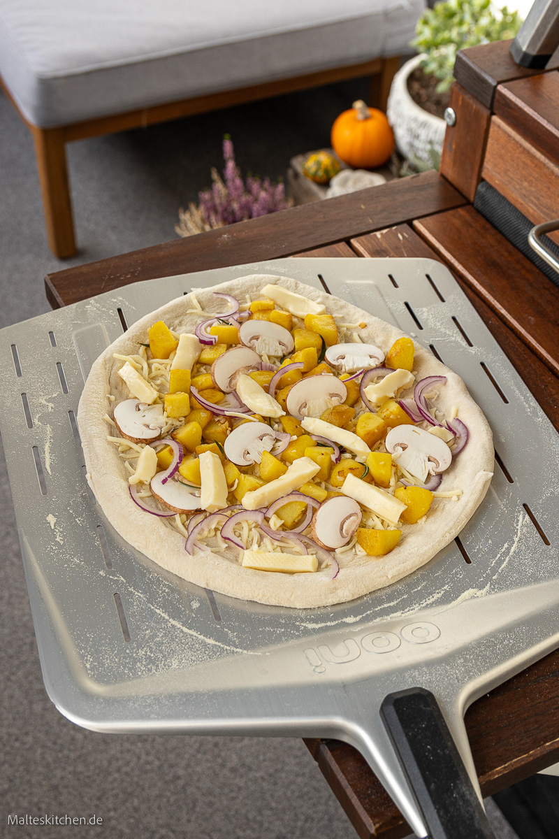 Die belegte Kartoffelpizza mit Champignons und Käse.