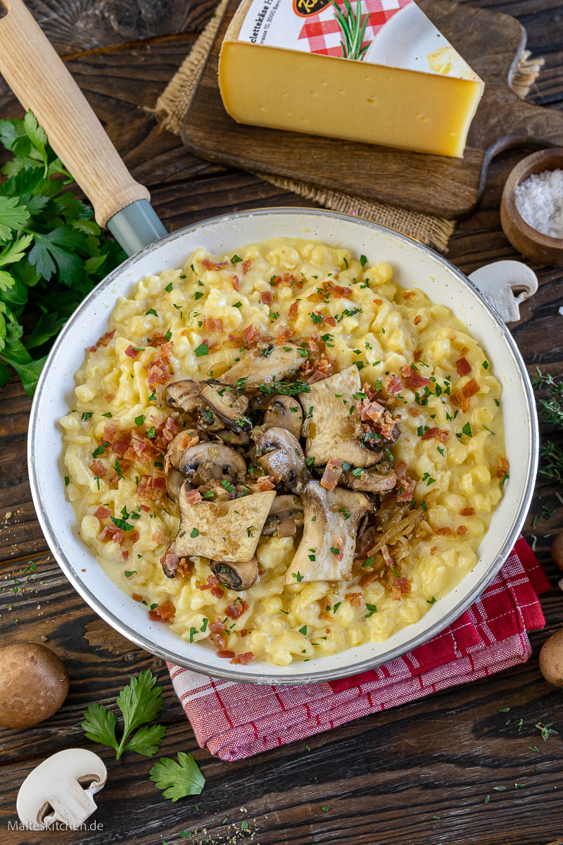 Knöpflepfanne mit Raclette Suisse, gebratenen Pilzen und Bacon