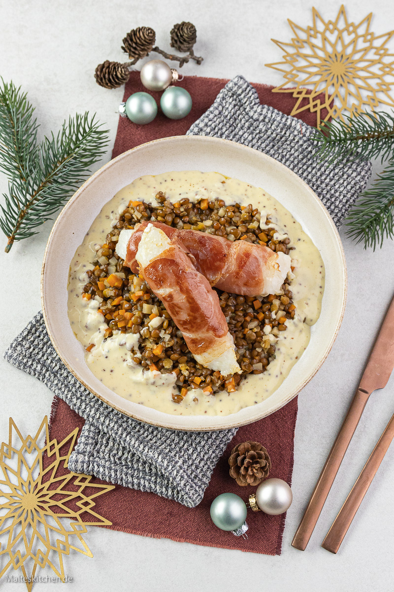 Kabeljau im Parmaschinkenmantel auf Linsengemüse.