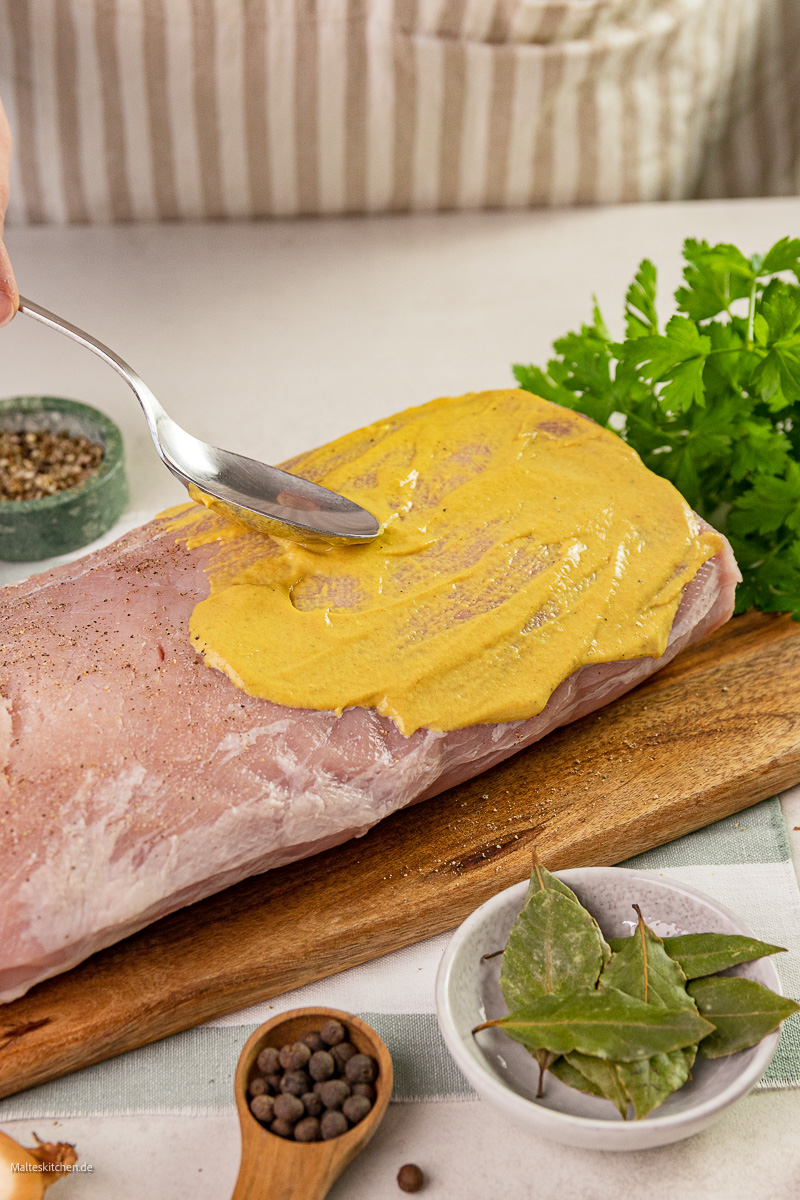 Der Braten wird mit Senf gewürzt.