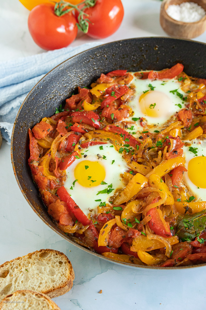 Schakschuka mit Paprika, Tomaten, Zwiebeln und Eiern.