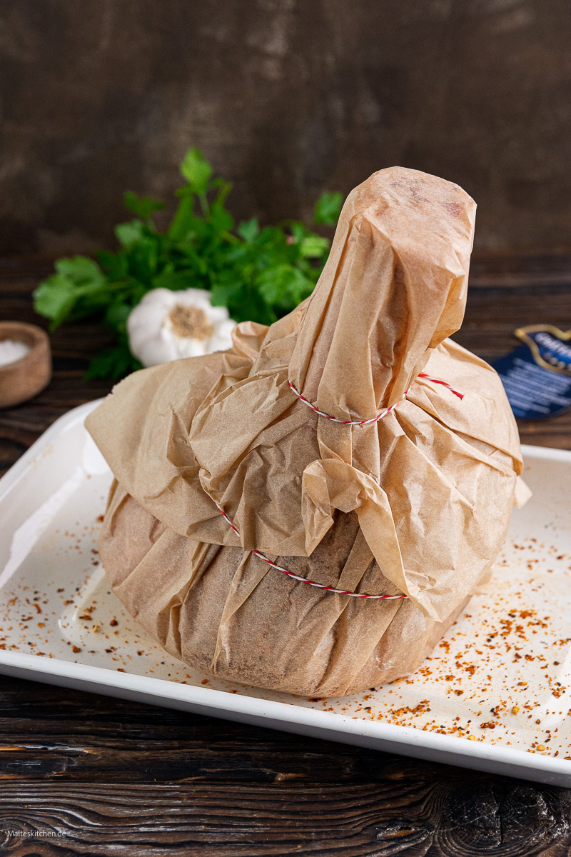 Das Fleisch wird in Backpapier gewickelt.