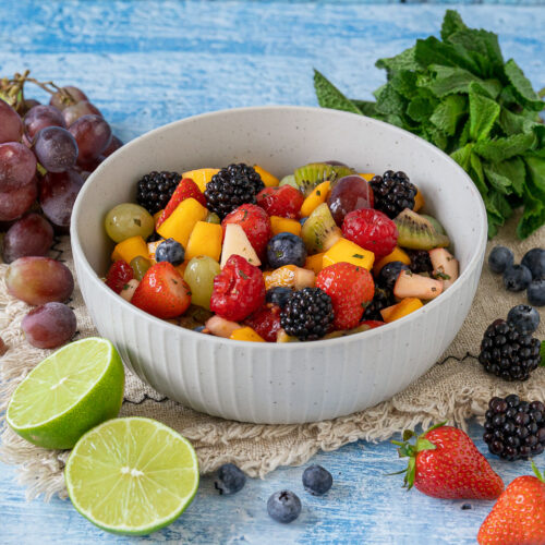 Obstsalat mit Mango, Beeren und Honig
