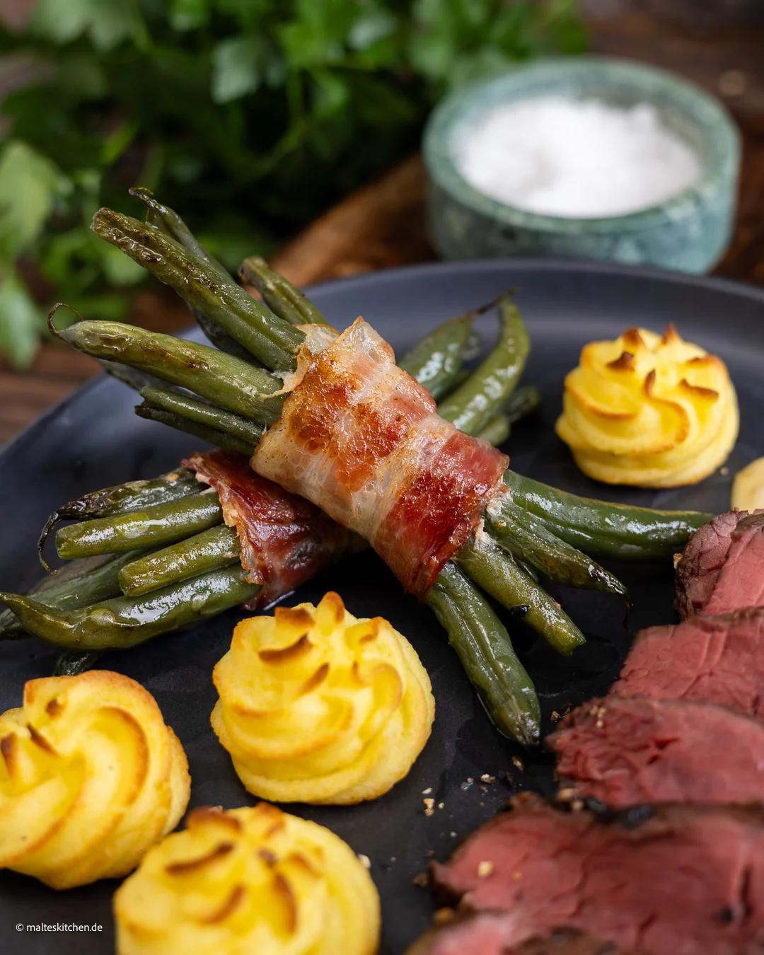 Steak mit grünen Bohnen im Speckmantel.