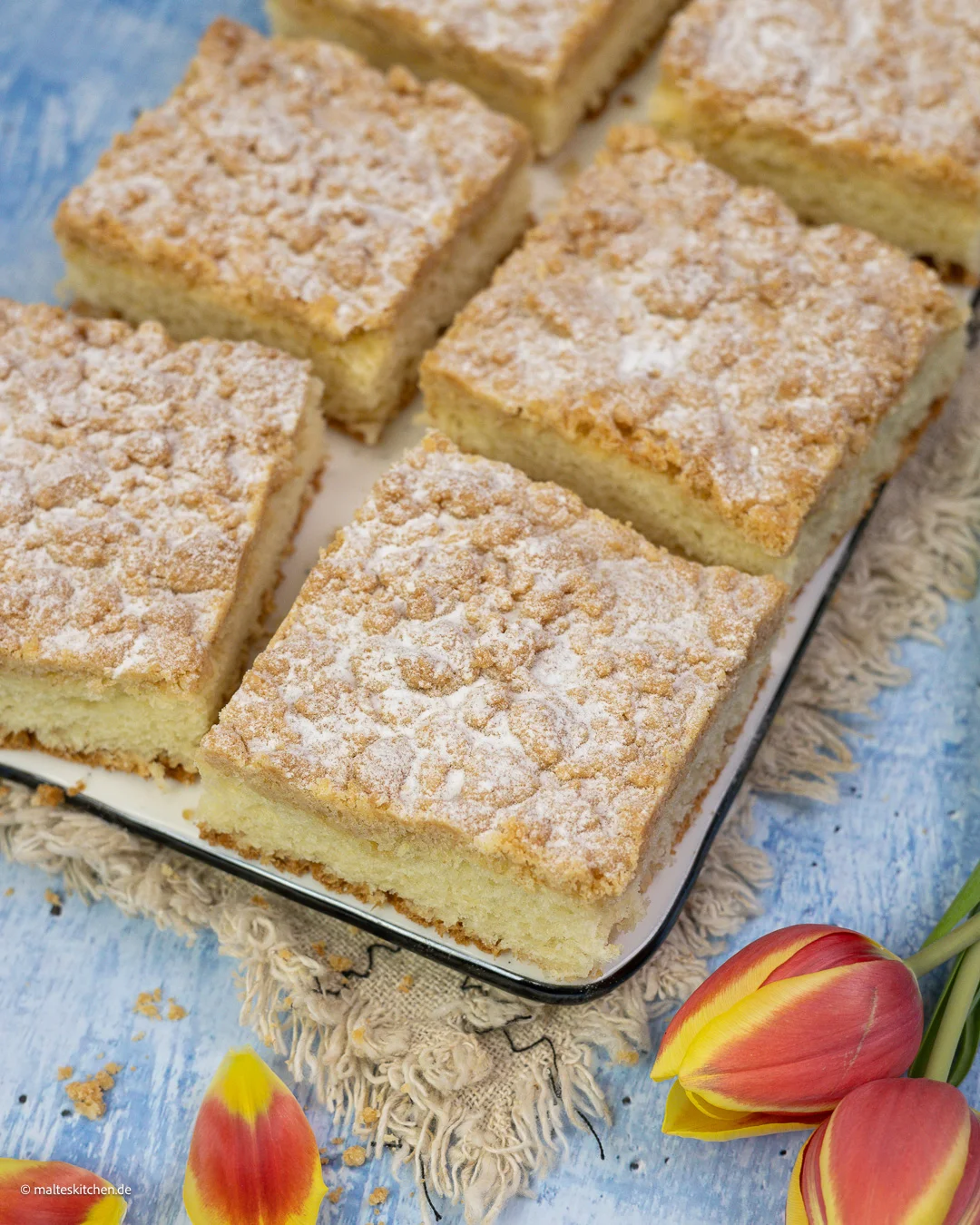 Streusel mit Puderzucker auf einem weichen Hefeteig.
