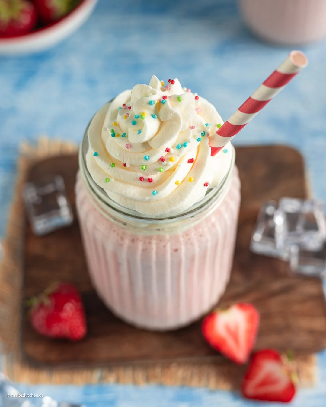Leckerer Milchshake mit Erdbeeren und Sahne.