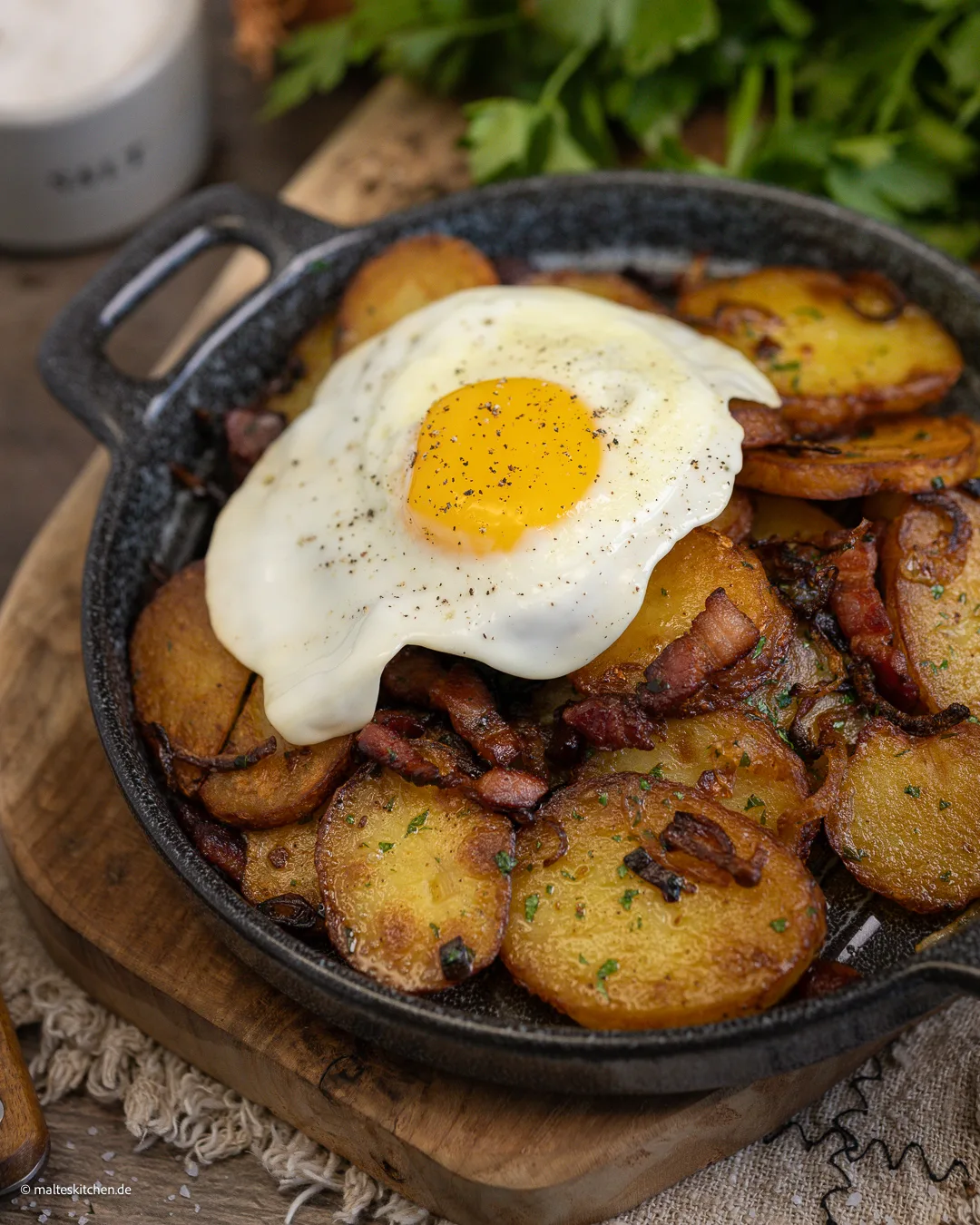 Leckere Bratkartoffeln mit Spiegelei und Speck.
