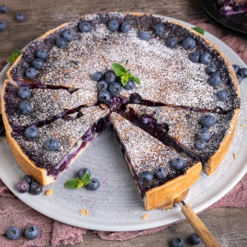 Gedeckter Heidelbeerkuchen mit Sahneguss